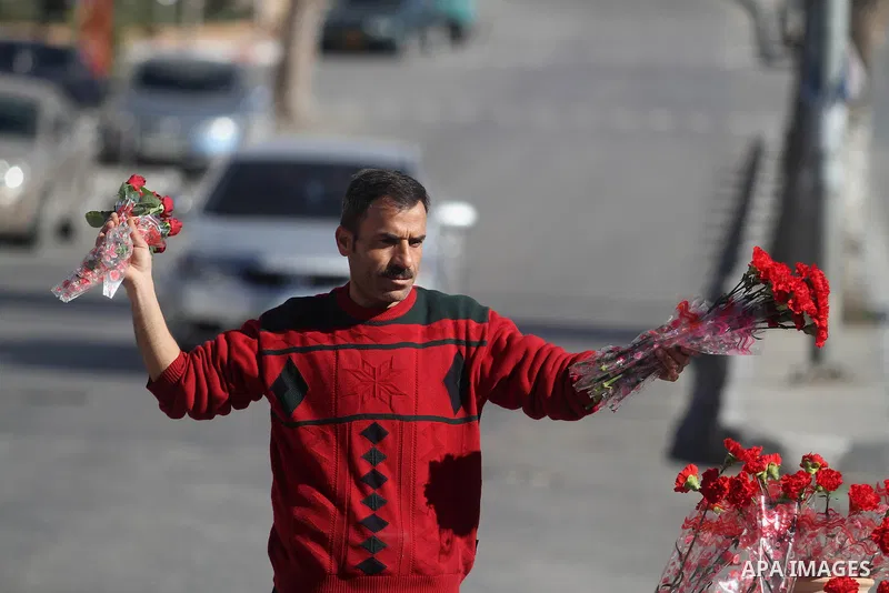 A Palestinian vendor sells a flowers ahead of Valentine's day at streets in the West Bank city of Ramallah, on Feb. 13, 2014. Valentine's Day is increasingly popular among younger Palestinians, many of whom have taken up...
