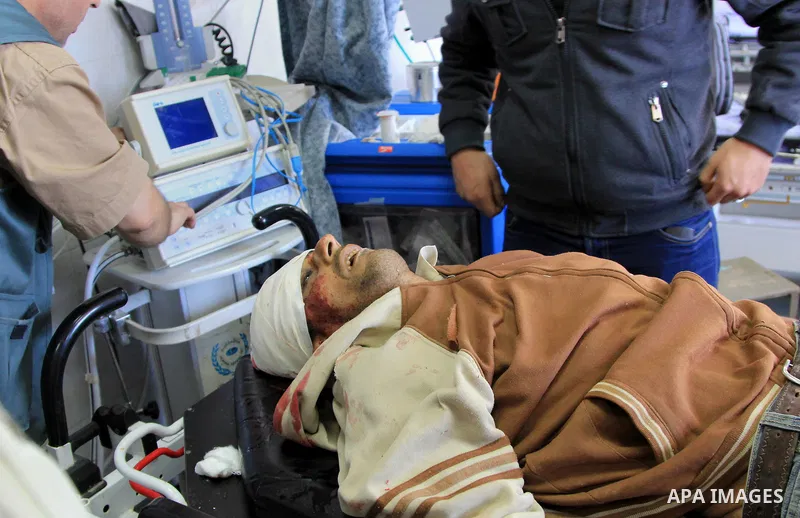 Palestinian relatives stand next to the body of Ibrahim Suleiman Mansour, 26, dead by Israeli security forces at a hospital in Gaza City on February 13, 2014. A Palestinian man was moderately injured Thursday and another...