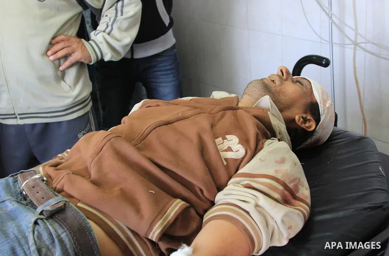 Palestinian relatives stand next to the body of Ibrahim Suleiman Mansour, 26, dead by Israeli security forces at a hospital in Gaza City on February 13, 2014. A Palestinian man was moderately injured Thursday and another...