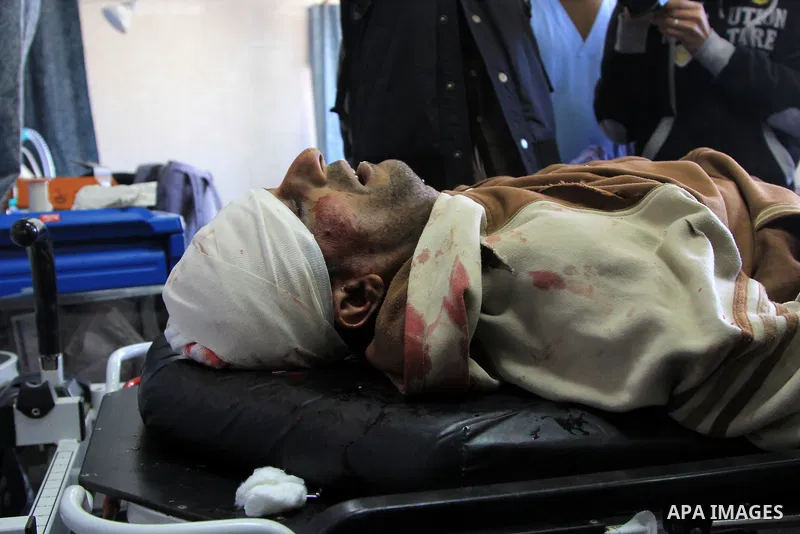 Palestinian relatives stand next to the body of Ibrahim Suleiman Mansour, 26, dead by Israeli security forces at a hospital in Gaza City on February 13, 2014. A Palestinian man was moderately injured Thursday and another...