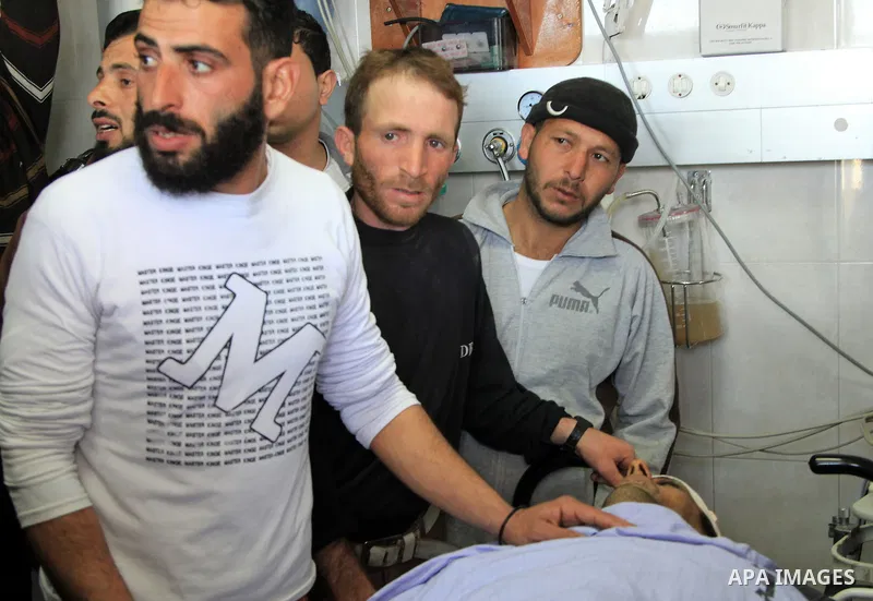 Palestinian relatives stand next to the body of Ibrahim Suleiman Mansour, 26, dead by Israeli security forces at a hospital in Gaza City on February 13, 2014. A Palestinian man was moderately injured Thursday and another...