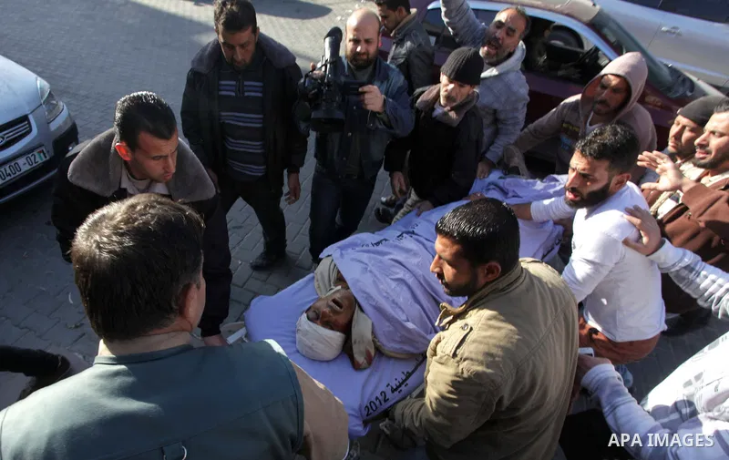 Palestinian medics wheel the body of Ibrahim Suleiman Mansour, 26, dead by Israeli security forces at a hospital in Gaza City on February 13, 2014. A Palestinian man was moderately injured Thursday and another died from...