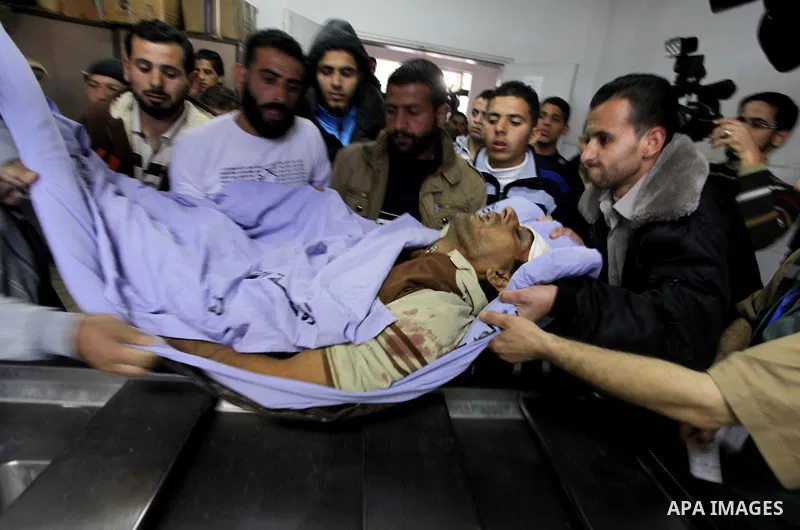 Palestinian medics carry the body of Ibrahim Suleiman Mansour, 26, dead by Israeli security forces at a hospital in Gaza City on February 13, 2014. A Palestinian man was moderately injured Thursday and another died from...