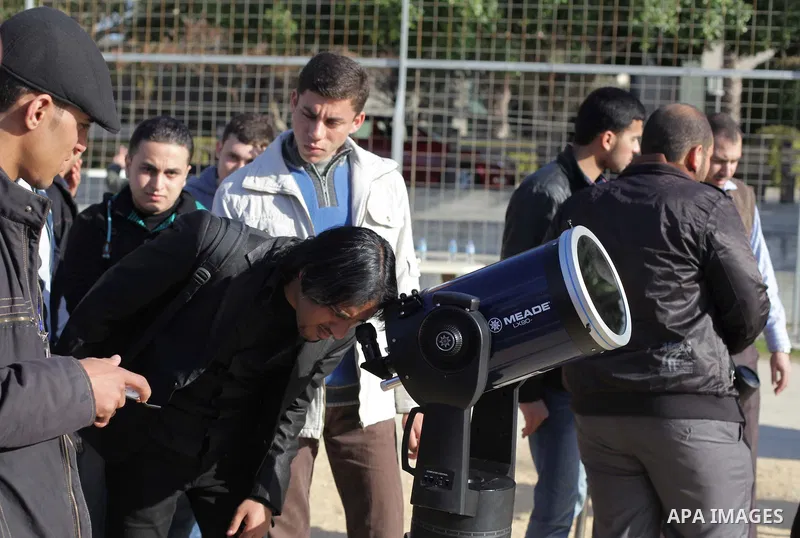 A Palestinian student looks through a telescope at the sun during a practical astronomer training to identify the Sunspot color and its impact, in Gaza City on February 13, 2014. Photo by Ashraf Amra