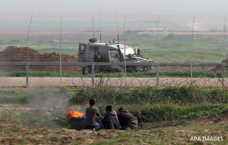 Palestinian protesters take a cover during clashes with Israeli forces near the border with Israel, east of Jabalia refugee camp in northern Gaza Strip on February 14, 2014. The Israeli army fired live rounds and tear ga...