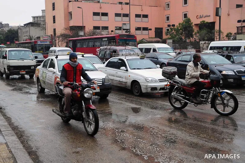Egyptians ride a motorbikes on a street flooded due to the rain in Cairo, Egypt, Saturday, Feb. 15, 2014. An unusual outbreak of rain poured down on Cairo on Saturday, flooding some streets to worsen the Egyptian capital...