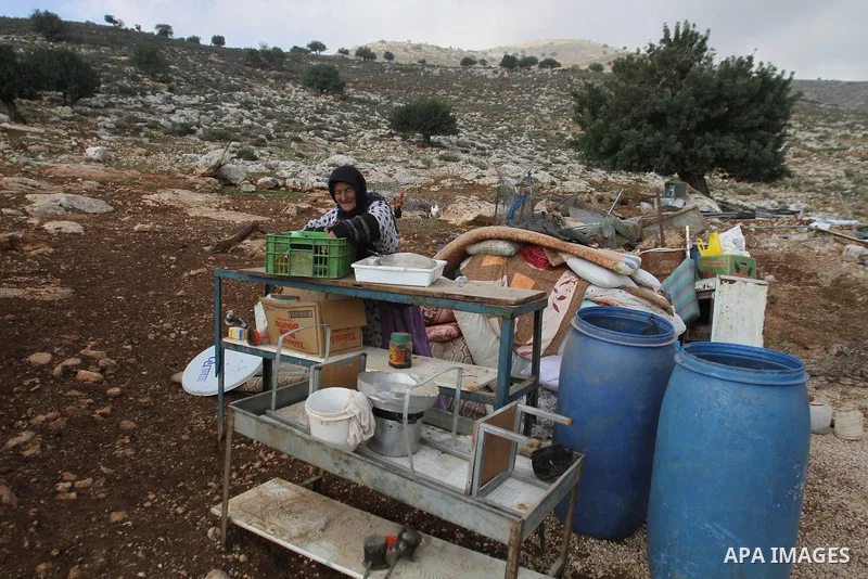 A Palestinian Bedouin woman inspects the remains of her tent after it was demolished near the Palestinian West Bank town of Tubas in the Jordan valley, on Feb. 17, 2014. Palestinians said the Israeli military demolished...