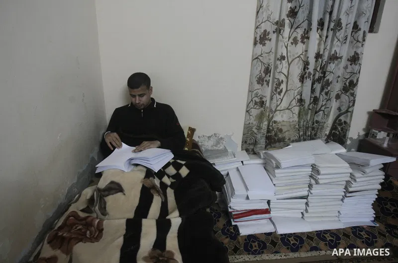 Palestinian Mahmoud Juhaish, 23, a blind youth studies at his house in Rafah refugee camp in southern Gaza strip on Feb. 17, 2014. Juhaish studies at the Islamic University in Gaza City as he suffers blindness, after his...