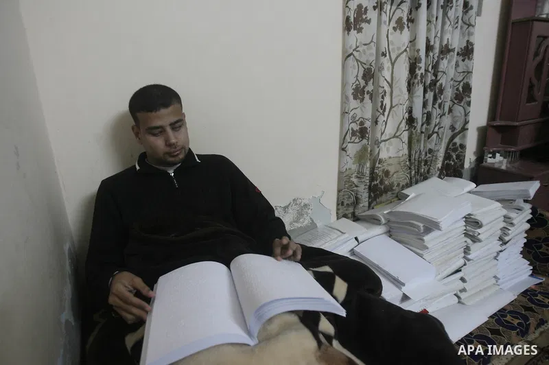 Palestinian Mahmoud Juhaish, 23, a blind youth studies at his house in Rafah refugee camp in southern Gaza strip on Feb. 17, 2014. Juhaish studies at the Islamic University in Gaza City as he suffers blindness, after his...