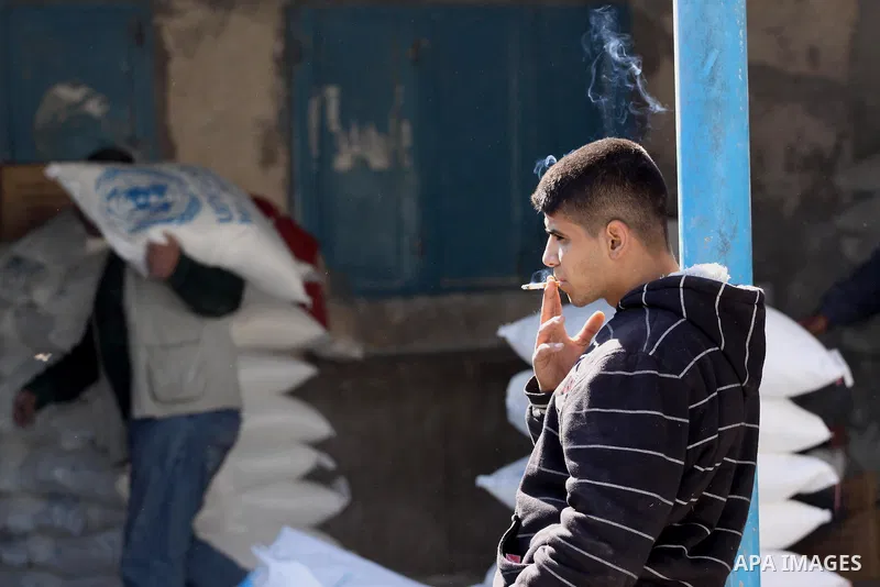 A Palestinian man holds a sack of flour at monthly food aid at a UN distribution center in Gaza city, on Feb. 18, 2014. The UN Relief and Works Agency (UNRWA) will reduce some of its services for Palestinian refugees due...