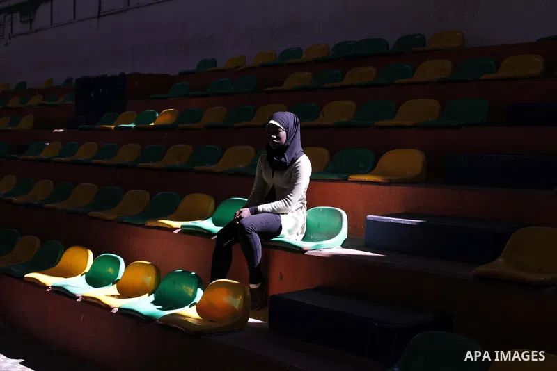 A Palestinian woman watches blind players as they paly goalball during a training course, in Gaza city on Feb. 18, 2014. Photo by Ashraf Amra