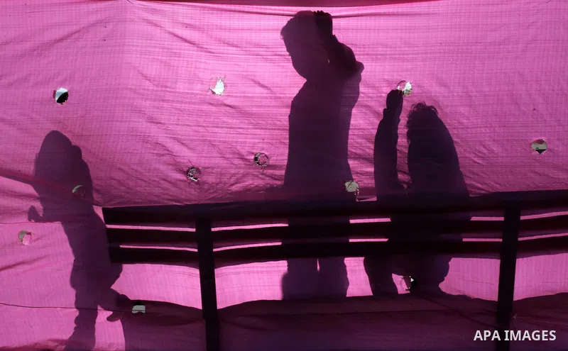 The silhouette of Palestinian children is seen behind a plastic sheet as they play outside their family's house, in Gaza City on February 18, 2014. Photo by Ashraf Amra