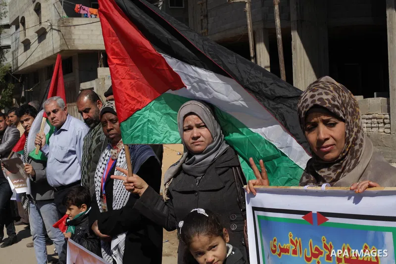 Palestinians hold Palestinian flags and pictures of prisoners during a protest in solidarity with sick prisoners in Israeli jails in Gaza City, on Feb. 19, 2014. Photo by Ashraf Amra