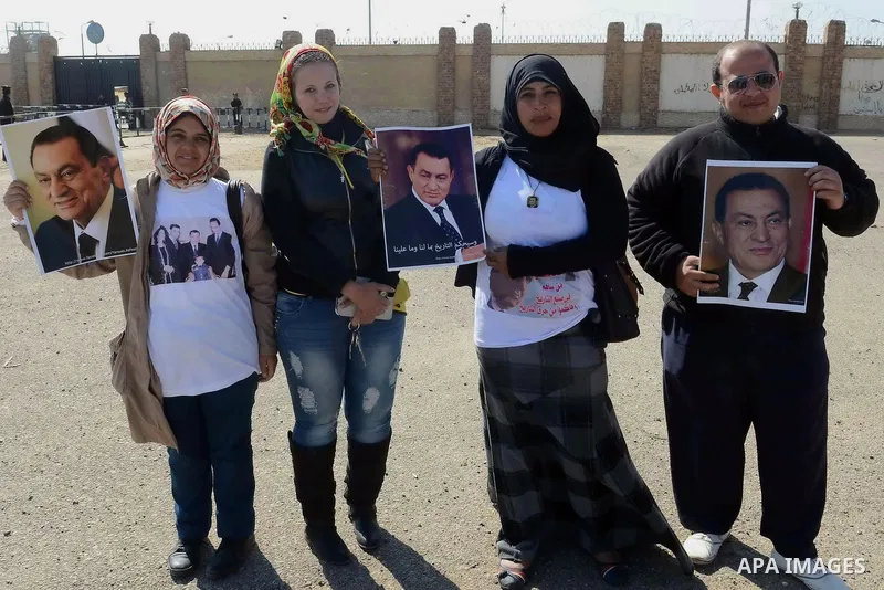 Supporters of former Egyptian president Hosni Mubarak hold his poster outside the police academy in Cairo, Egypt, on Feb. 19, 2014. Photo by Mohammed Bendari