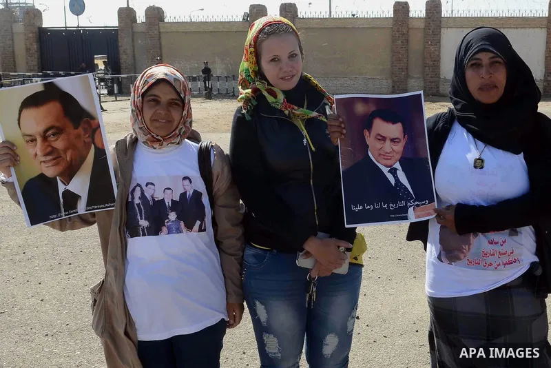 Supporters of former Egyptian president Hosni Mubarak hold his poster outside the police academy in Cairo, Egypt, on Feb. 19, 2014. Photo by Mohammed Bendari