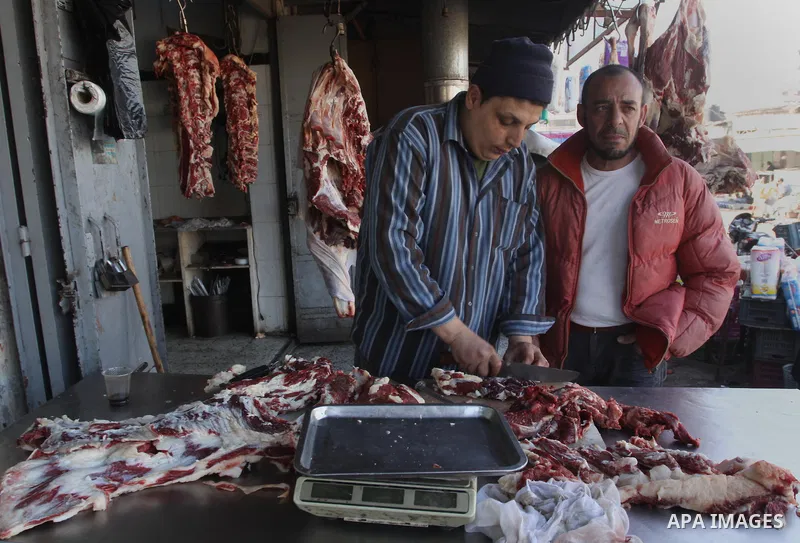 A Palestinian butcher cuts fresh meat at his slaughterhouse in Gaza city on Feb. 19, 2014. Palestinian butchers campaign discounts on prices of fresh meat to confront the sharp reduction in demand due to the blockaded te...