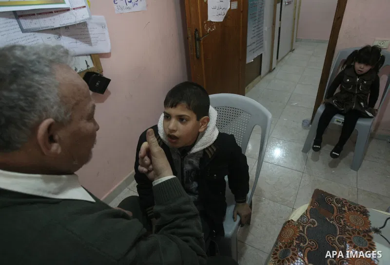 Mahmoud Abu Rous, 45, A Palestinian man teaches kids with speech disorder during a phonics lesson in Rafah in southern Gaza city, February 19, 2014. Abu Rous teaching kids the acquisition of all facets of language, from...