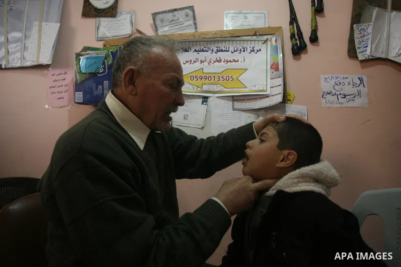 Mahmoud Abu Rous, 45, A Palestinian man teaches kids with speech disorder during a phonics lesson in Rafah in southern Gaza city, February 19, 2014. Abu Rous teaching kids the acquisition of all facets of language, from...