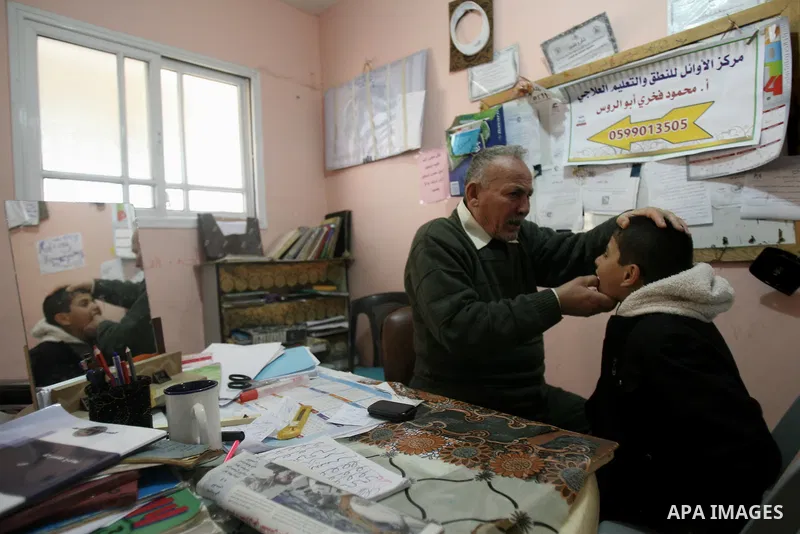 Mahmoud Abu Rous, 45, A Palestinian man teaches kids with speech disorder during a phonics lesson in Rafah in southern Gaza city, February 19, 2014. Abu Rous teaching kids the acquisition of all facets of language, from...