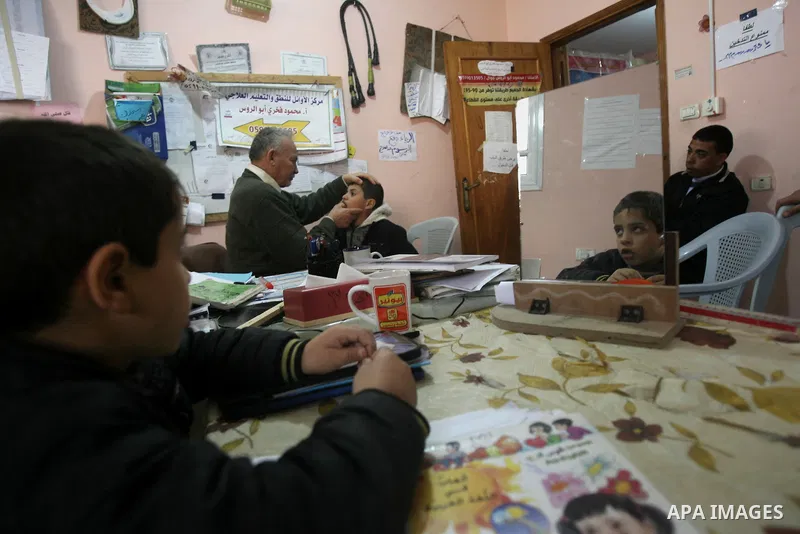 Mahmoud Abu Rous, 45, A Palestinian man teaches kids with speech disorder during a phonics lesson in Rafah in southern Gaza city, February 19, 2014. Abu Rous teaching kids the acquisition of all facets of language, from...