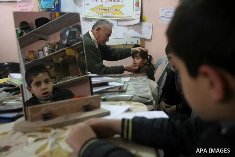 Mahmoud Abu Rous, 45, A Palestinian man teaches kids with speech disorder during a phonics lesson in Rafah in southern Gaza city, February 19, 2014. Abu Rous teaching kids the acquisition of all facets of language, from...