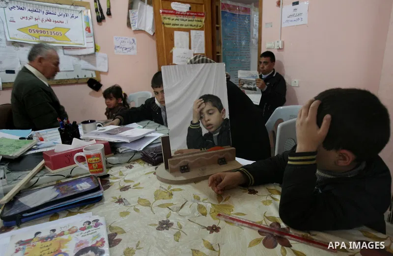 Mahmoud Abu Rous, 45, A Palestinian man teaches kids with speech disorder during a phonics lesson in Rafah in southern Gaza city, February 19, 2014. Abu Rous teaching kids the acquisition of all facets of language, from...