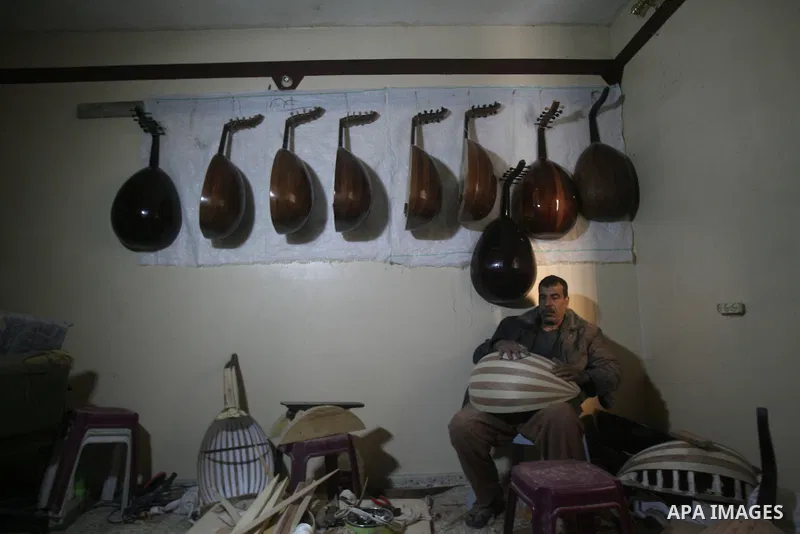 Hammad Atwa, a Palestinian man who makes lutes, known in Arabic as an "Oud", works on a musical instrument at the Khan Younis refugee camp in the southern Gaza Strip on February 19, 2014. Hammad sells his handmade lutes...