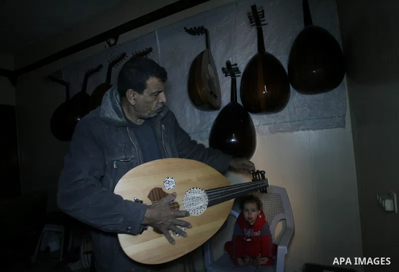 Hammad Atwa, a Palestinian man who makes lutes, known in Arabic as an "Oud" shows one of his handmade musical instruments at the Khan Younis refugee camp in the southern Gaza Strip on February 19, 2014. Hammad sells his...