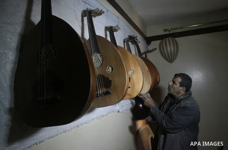 Hammad Atwa, a Palestinian man who makes lutes, known in Arabic as an "Oud" shows one of his handmade musical instruments at the Khan Younis refugee camp in the southern Gaza Strip on February 19, 2014. Hammad sells his...