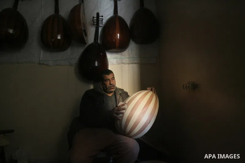 Hammad Atwa, a Palestinian man who makes lutes, known in Arabic as an "Oud", works on a musical instrument at the Khan Younis refugee camp in the southern Gaza Strip on February 19, 2014. Hammad sells his handmade lutes...