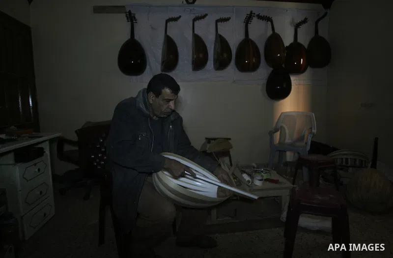 Hammad Atwa, a Palestinian man who makes lutes, known in Arabic as an "Oud", works on a musical instrument at the Khan Younis refugee camp in the southern Gaza Strip on February 19, 2014. Hammad sells his handmade lutes...
