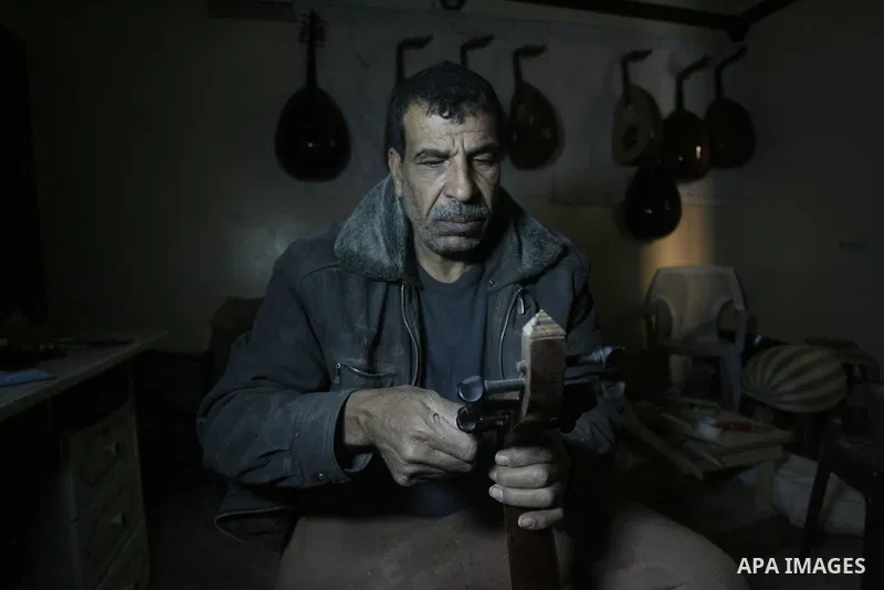 Hammad Atwa, a Palestinian man who makes lutes, known in Arabic as an "Oud", works on a musical instrument at the Khan Younis refugee camp in the southern Gaza Strip on February 19, 2014. Hammad sells his handmade lutes...