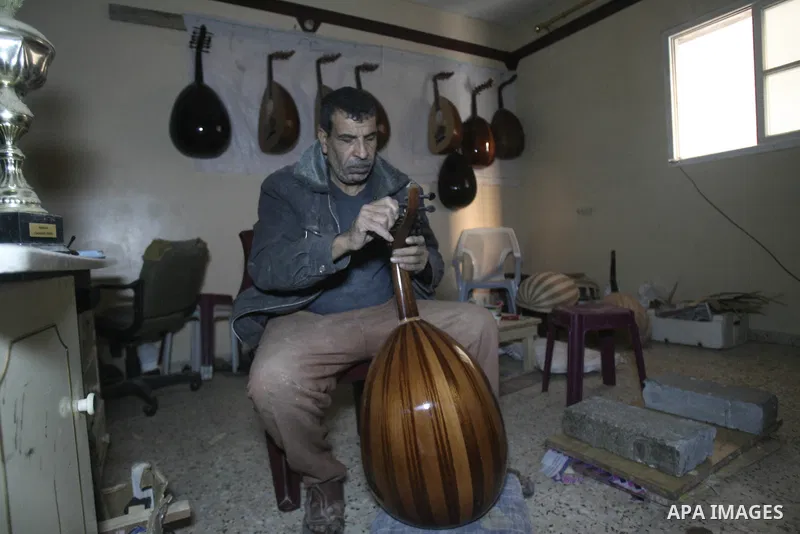 Hammad Atwa, a Palestinian man who makes lutes, known in Arabic as an "Oud", works on a musical instrument at the Khan Younis refugee camp in the southern Gaza Strip on February 19, 2014. Hammad sells his handmade lutes...