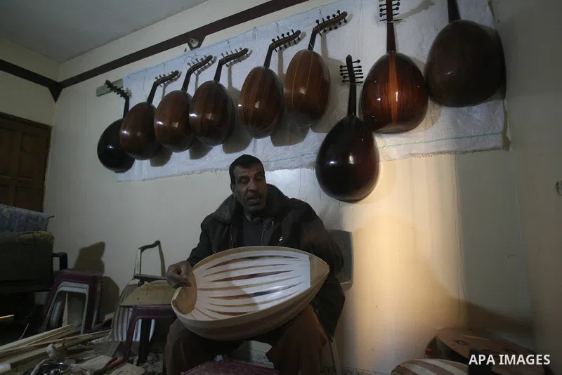 Hammad Atwa, a Palestinian man who makes lutes, known in Arabic as an "Oud", works on a musical instrument at the Khan Younis refugee camp in the southern Gaza Strip on February 19, 2014. Hammad sells his handmade lutes...