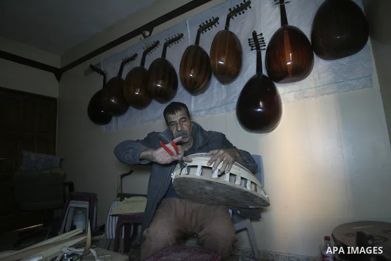 Hammad Atwa, a Palestinian man who makes lutes, known in Arabic as an "Oud", works on a musical instrument at the Khan Younis refugee camp in the southern Gaza Strip on February 19, 2014. Hammad sells his handmade lutes...