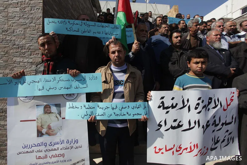 Palestinians hold banners during a protest against the attack on the former Palestinian minister of prisoners, Wasfi Kabha, in front of the Legislative Legislative in Gaza on Feb. 20, 2014. Photo by Ashraf Amra