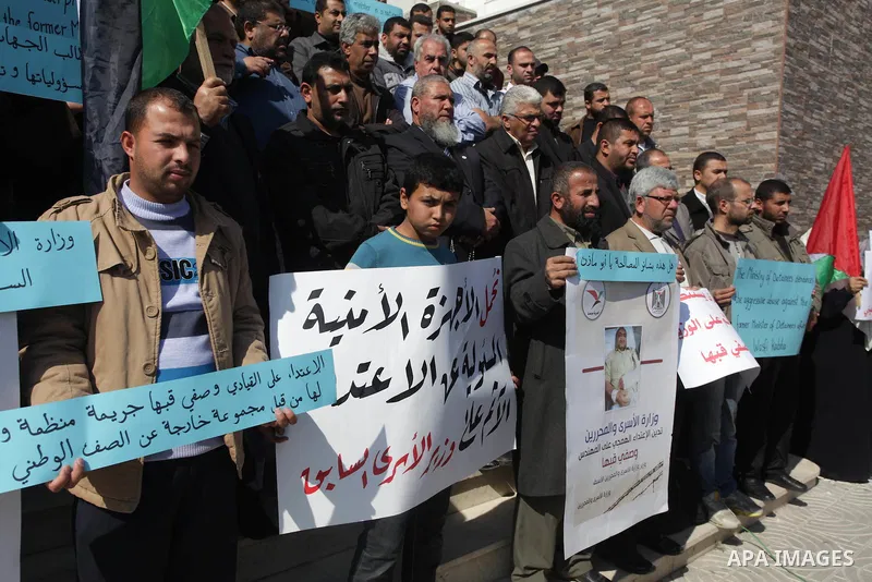 Palestinians hold banners during a protest against the attack on the former Palestinian minister of prisoners, Wasfi Kabha, in front of the Legislative Legislative in Gaza on Feb. 20, 2014. Photo by Ashraf Amra
