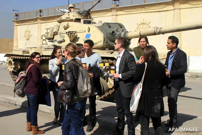 Journalists wait outside court adjacent to Tora prison as 20 Al-Jazeera employees are on trial accused of membership in the Muslim Brotherhood and also for aiding it in Cairo, Egypt, Thursday, Feb. 20, 2014. A rights gro...