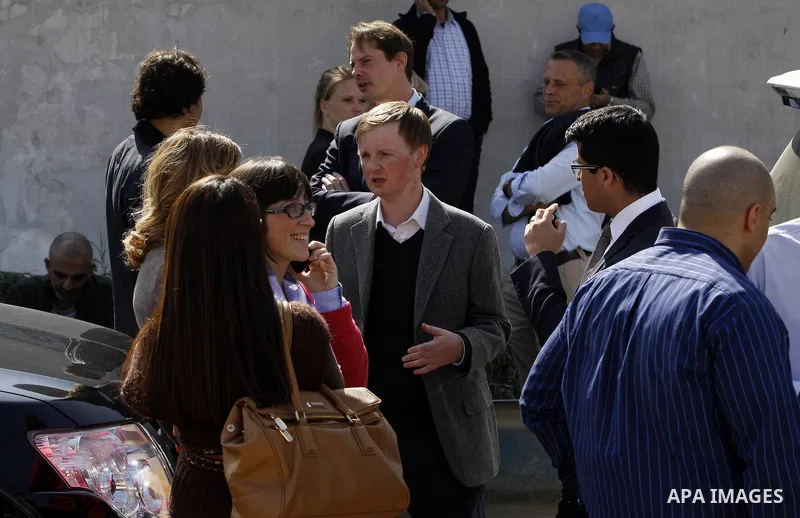 Journalists wait outside court adjacent to Tora prison as 20 Al-Jazeera employees are on trial accused of membership in the Muslim Brotherhood and also for aiding it in Cairo, Egypt, Thursday, Feb. 20, 2014. A rights gro...