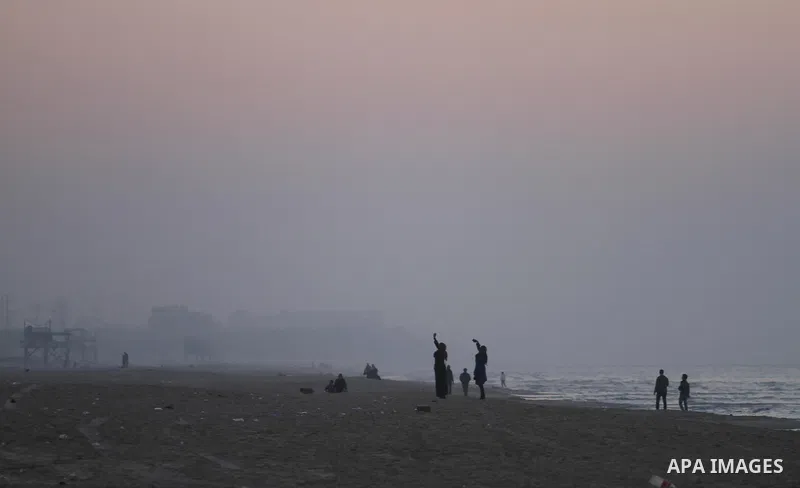 Palestinian women use their cellphones to take photos under heavy fog at the Mediterranean Sea beach front in Gaza City, Thursday, Feb. 20, 2014. Photo by Mohammed Asad