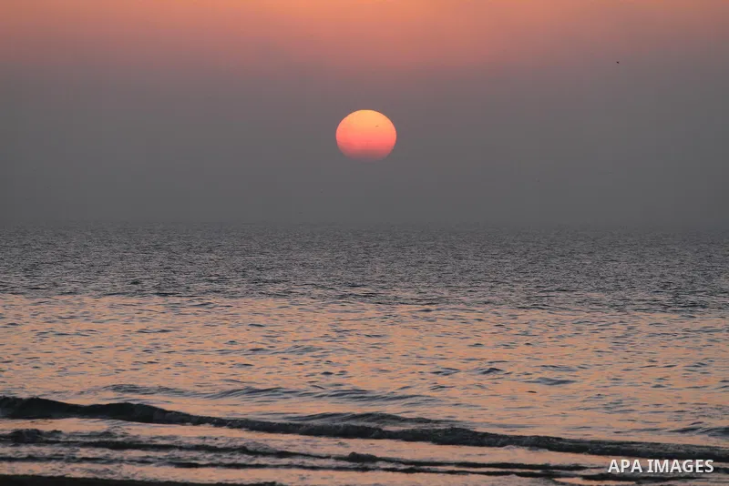 The sunset is seen under heavy fog at the Mediterranean Sea beach front in Gaza City, Thursday, Feb. 20, 2014. Photo by Mohammed Asad