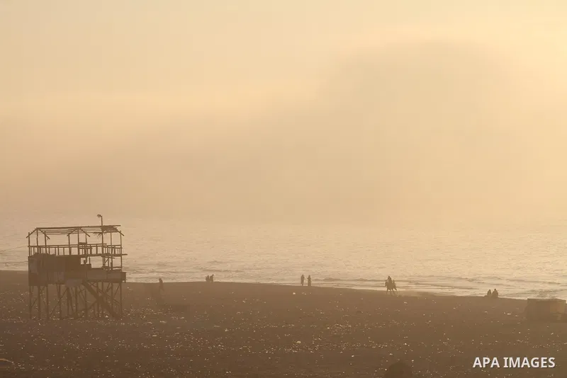Palestinian enjoy the beach under heavy fog at the Mediterranean Sea beach front in Gaza City, Thursday, Feb. 20, 2014. Photo by Mohammed Asad