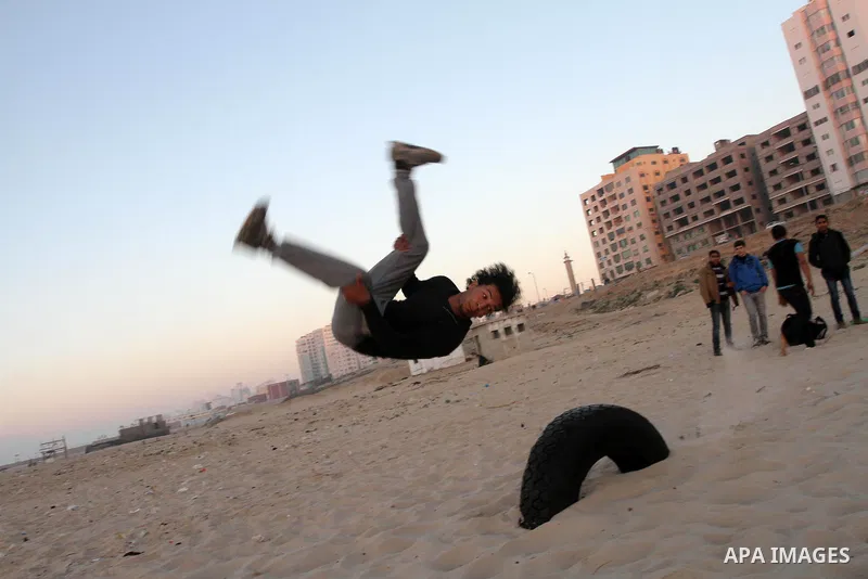 A Palestinian youth practices parkour skills at the Mediterranean Sea beach front in Gaza City, Thursday, Feb. 20, 2014. Parkour, French slang for the art of moving, is a physical activity that maximizes the body's effic...