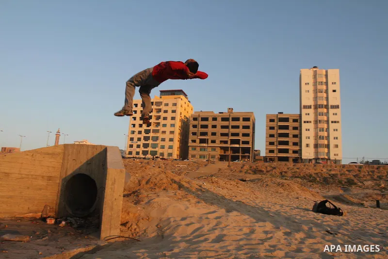 A Palestinian youth practices parkour skills at the Mediterranean Sea beach front in Gaza City, Thursday, Feb. 20, 2014. Parkour, French slang for the art of moving, is a physical activity that maximizes the body's effic...