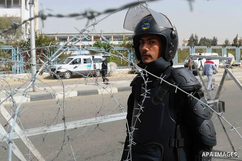 Egyptian security forces stand guard as ousted Egyptian president Morsi and 14 other defendants arrive at Cairo's Police Academy, cairo, on Feb. 22, 2014. Morsi, toppled in July by the military, faces a host of criminal...