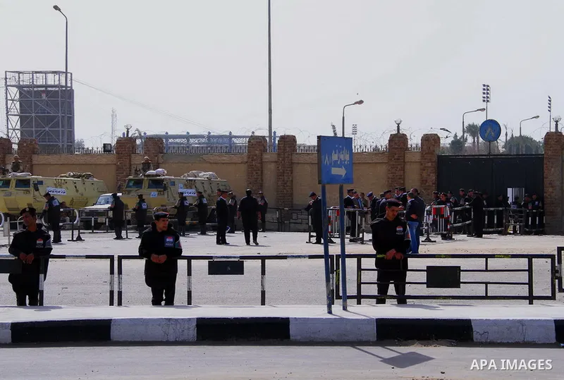 Egyptian security forces stand guard as ousted Egyptian president Morsi and 14 other defendants arrive at Cairo's Police Academy, cairo, on Feb. 22, 2014. Morsi, toppled in July by the military, faces a host of criminal...