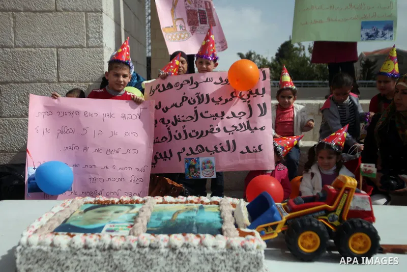 Palestinian members of Al Sawahra family celebrate Daoud Al Sawahra, 5, birthday at the yard of Jerusalem Municipality in a protest against demolishing their house by Israeli authority in Jerusalem, on Feb. 23, 2014. Isr...