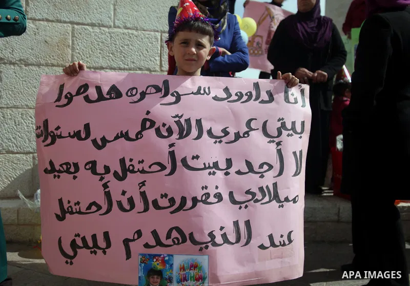 Palestinian members of Al Sawahra family celebrate Daoud Al Sawahra, 5, birthday at the yard of Jerusalem Municipality in a protest against demolishing their house by Israeli authority in Jerusalem, on Feb. 23, 2014. Isr...