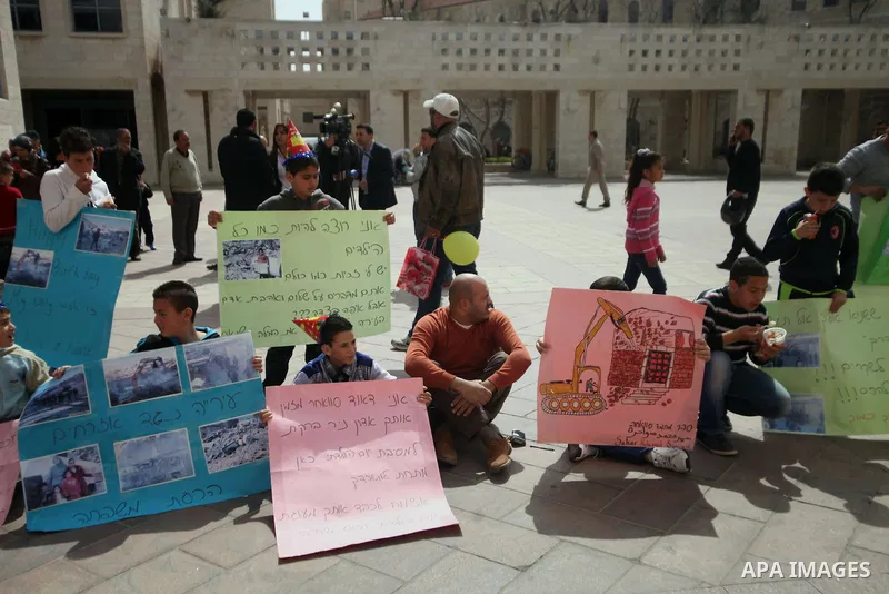 Palestinian members of Al Sawahra family celebrate Daoud Al Sawahra, 5, birthday at the yard of Jerusalem Municipality in a protest against demolishing their house by Israeli authority in Jerusalem, on Feb. 23, 2014. Isr...