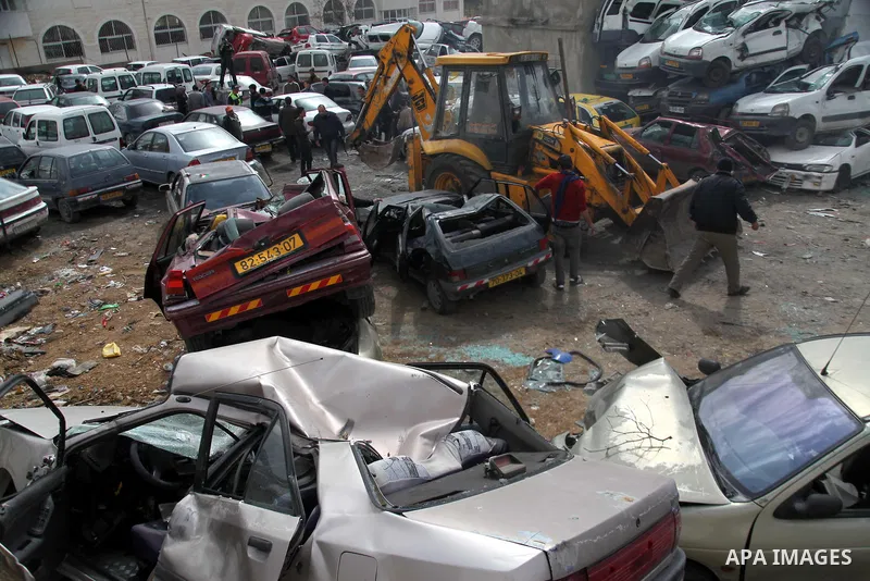 Palestinian police members use a bulldozer to destroy cars during a campaign destroy illegal cars in the West Bank City of Hebron, February 23, 2014. A majority of the so-called "illegal" vehicles are cars bought or stol...